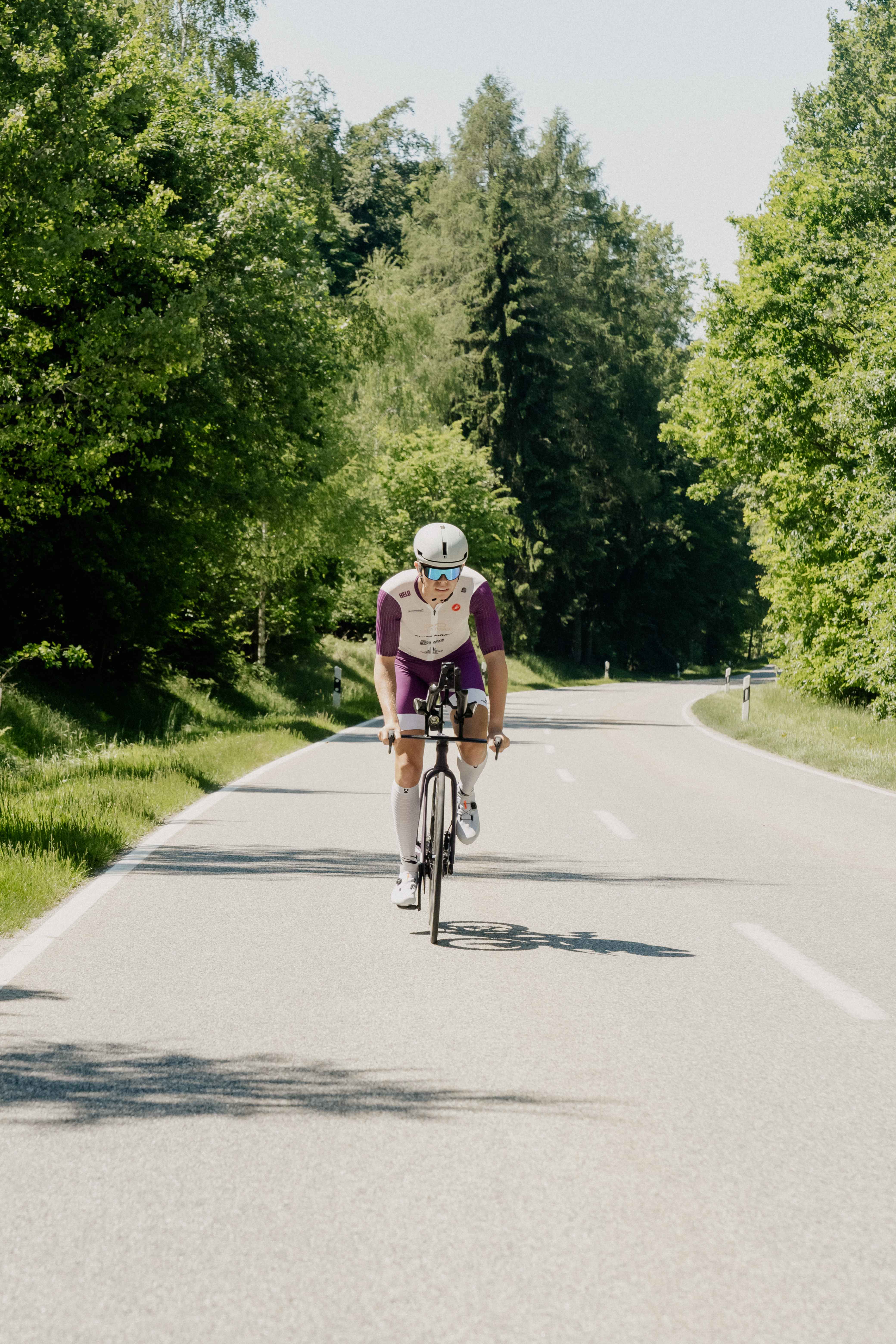 Benedikt auf dem Zeitfahrrad auf einer Allee